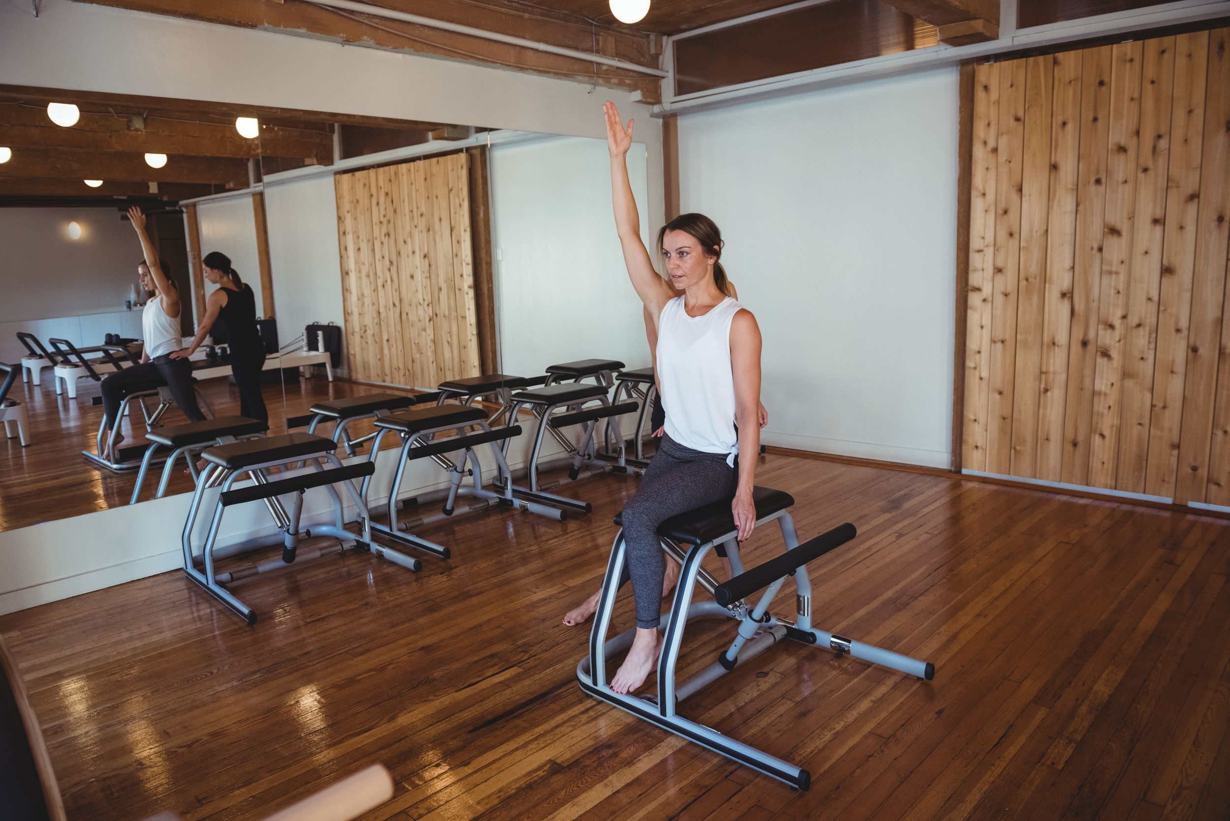 trainer-helping-woman-while-practicing-pilates